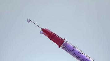 Jeringa de insulina inclinada con goteo de líquido púrpura video
