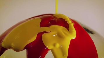 Red And Yellow Paint Dripping On Glass Sphere video
