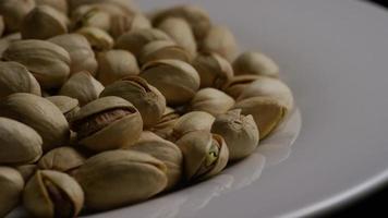 Cinematic, rotating shot of pistachios on a white surface - PISTACHIOS 040 video