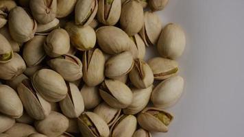 Cinematic, rotating shot of pistachios on a white surface - PISTACHIOS 029 video