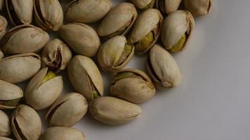 Cinematic, rotating shot of pistachios on a white surface - PISTACHIOS 005 video