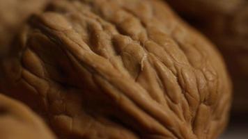 Cinematic, rotating shot of walnuts in their shells on a white surface - WALNUTS 026 video