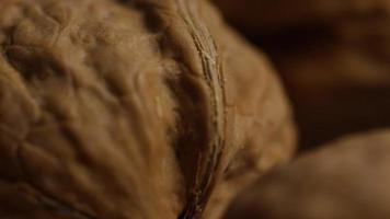 Cinematic, rotating shot of walnuts in their shells on a white surface - WALNUTS 025 video