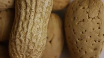 Cinematic, rotating shot of a variety of nuts on a white surface - NUTS MIXED 013 video
