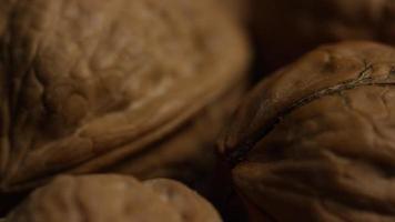 Cinematic, rotating shot of walnuts in their shells on a white surface - WALNUTS 080 video