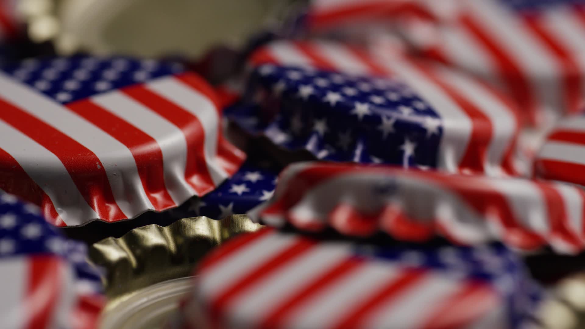 Rotating shot of bottle caps with the American flag printed on them
