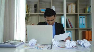 Stressed businessman hand holding crumpled business paper and anger video