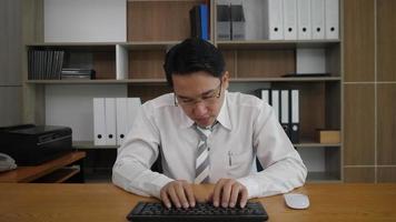 Businessman employee typing keyboard and looking at monitor computer while sleepy video