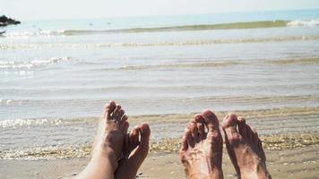 Mann und Frau Beine gegen das Meer am Sommerstrand, Zeit zu reisen. leerer Platz für einen Text