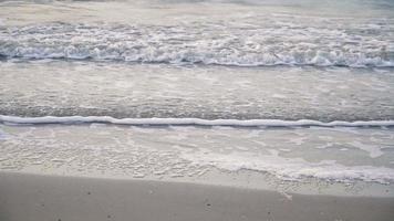 mjuk våg av havet på sandstranden. sommar textur bakgrund video