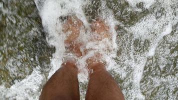 gros plan de pieds relaxants dans une cascade. video