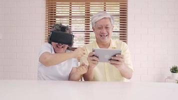 asiatiska äldre par som använder surfplatta och virtuell verklighetssimulator video