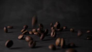 granos de café tostado marrón cayendo sobre una pila