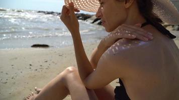 junge Frau, die Sonnenschutzmittel auf ihrer Schulter anwendet video