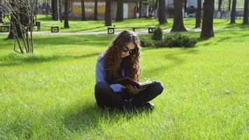 ung kvinna som läser i parken
