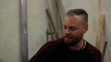 een man met een baard en een mohawk die een sigaret rookt video