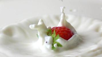 une fraise tombant dans le lait video