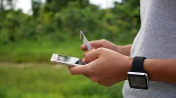 Manos de mujer sosteniendo una tarjeta de crédito y usando teléfonos inteligentes para compras en línea video