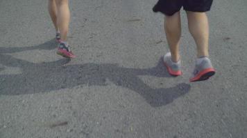cámara lenta - pareja de corredor asiático corriendo y trotando en la calle. video
