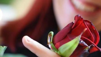 Valentinstag Geschenk. junges Mädchen, das auf einer roten Rose riecht