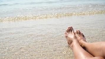 pés femininos contra o mar na praia de verão, hora de viajar. lugar vazio para um texto. Vídeo 4k video