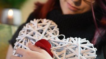 regalo di San Valentino. giovane ragazza con cuore in legno bianco con petali di rosa video