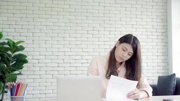 imprenditrice asiatica che dà caffè al suo collega che sta arrivando con il computer portatile in ufficio.