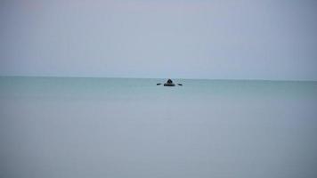 ensam båt i havet vid horisonten tidigt på morgonen.