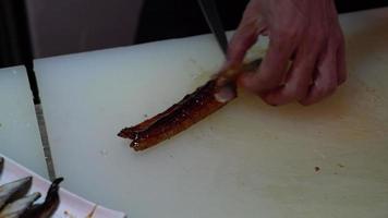 het snijden van gegrilde paling video