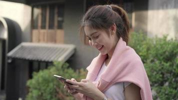 mulher de blogueiro mochileiro asiático alegre usando smartphone para orientação e olhando no mapa de localização video