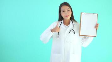 Asian doctor woman with board on blue background video