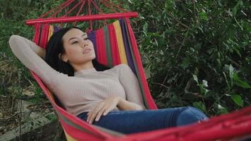 Beautiful young woman lying down to hammock sleeping and relax video