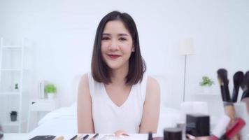 blogger de belleza presenta cosméticos de belleza sentados frente a la cámara frontal para grabar videos. video