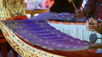 Mains frappant l'instrument de xylophone alto en bois thaïlandais