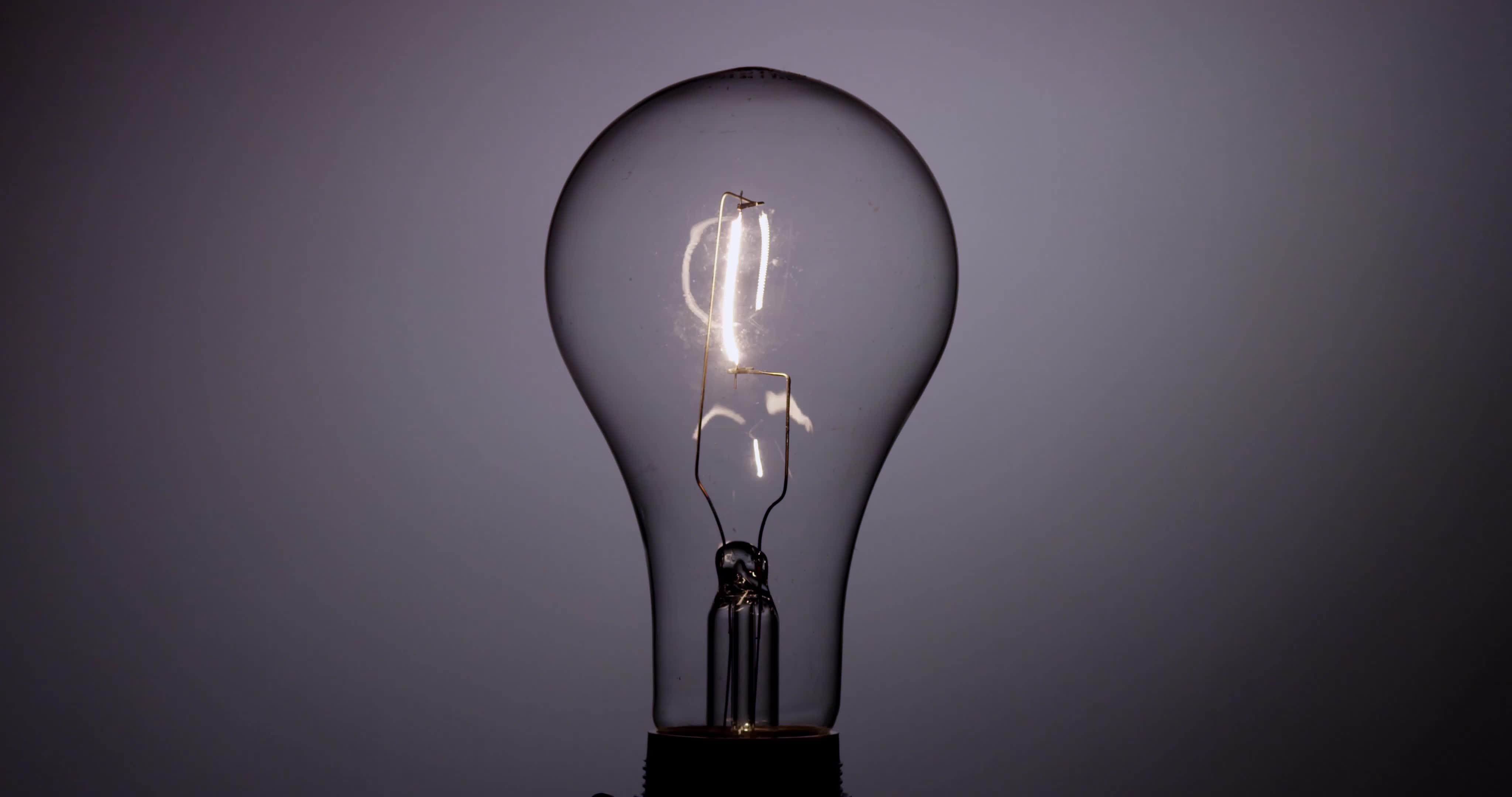 Classic light bulb turning off and flashing three times with orange