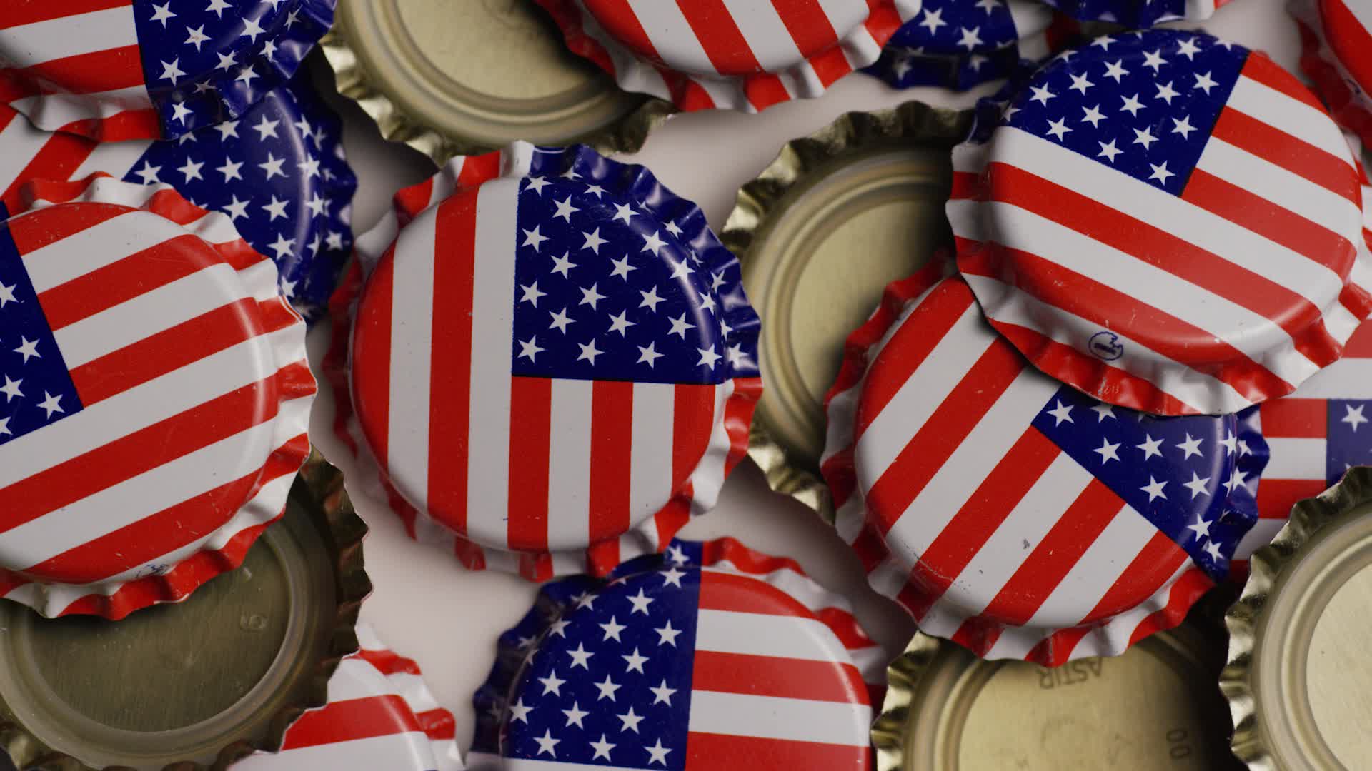 Rotating shot of bottle caps with the American flag printed on them