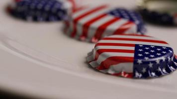 Rotating shot of bottle caps with the American flag printed on them - BOTTLE CAPS 019 video