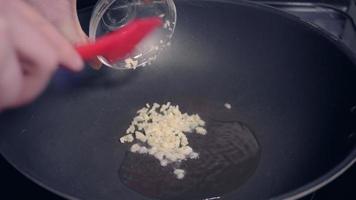Frying minced garlic with hot cooking oil in a wok video