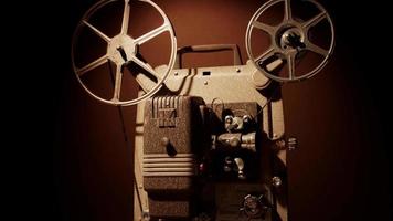 zijaanzichtclip van een persoon die een filmprojector aanzet met spoelen en mechanisme dat de film in 4k beweegt video