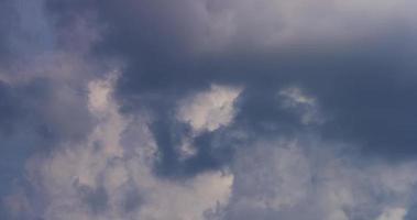 Time lapse of bright cumulus cloud moving fast with a dark cloud in foreground in 4K video