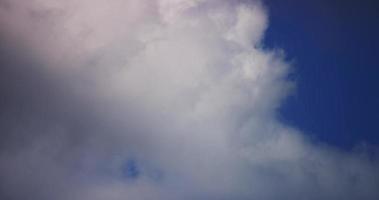 Time lapse of dynamic gray and white cumulus clouds on blue background in 4K video