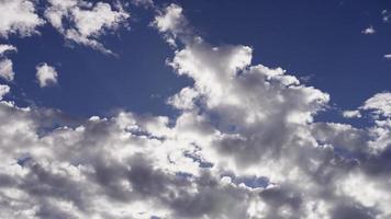 lapso de tiempo de las nubes altocúmulos moviéndose lentamente en el cielo azul brillante y los rayos del sol en 4k video