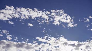 Laps de temps des nuages altocumulus se déplaçant lentement sur le ciel bleu avec des fusées éclairantes et le soleil en 4k video