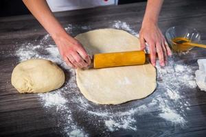 Hands baking dough with rolling pin photo