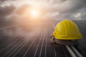 Yellow safety helmet on solar panel photo