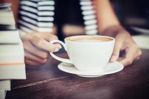Woman's hands relaxing with coffee at cafe photo