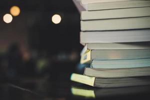 Piles of books on a table over a blurred library background photo