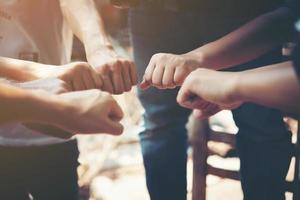 Close-up of young people putting their hands together photo