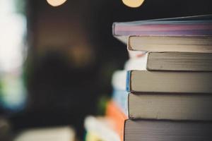 Montones de libros sobre una mesa sobre un fondo de biblioteca borrosa foto