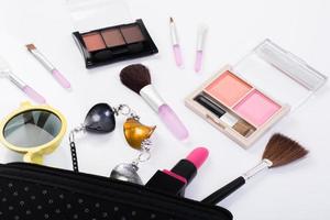 Vista superior de una bolsa de maquillaje con productos de belleza. foto